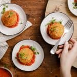 overhead view of small plates with crispy fried mashed potato balls with marinara sauce