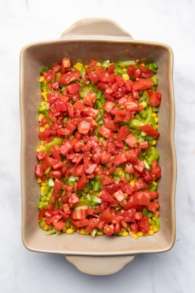 Corn and peppers and tomatoes in a casserole dish