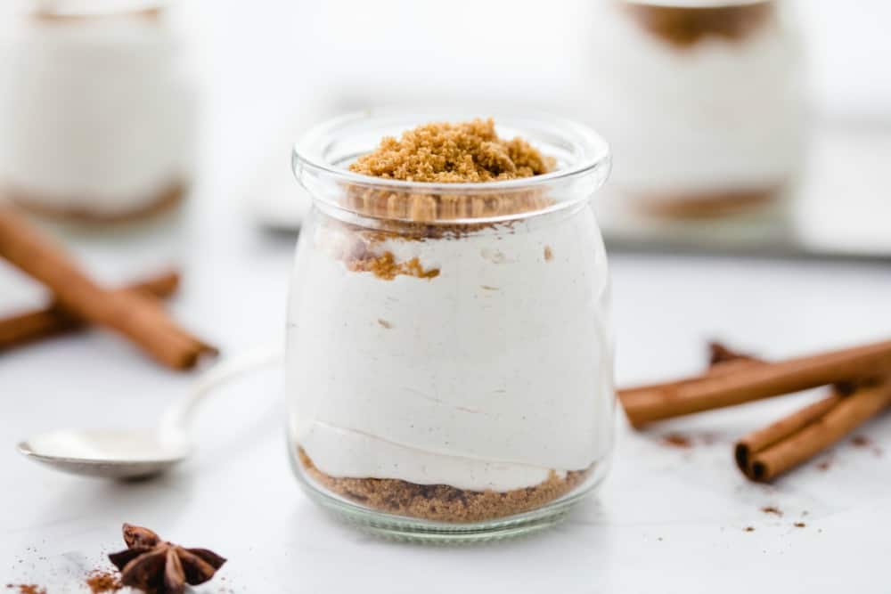 chai cheesecake cups on a white surface with warm spices
