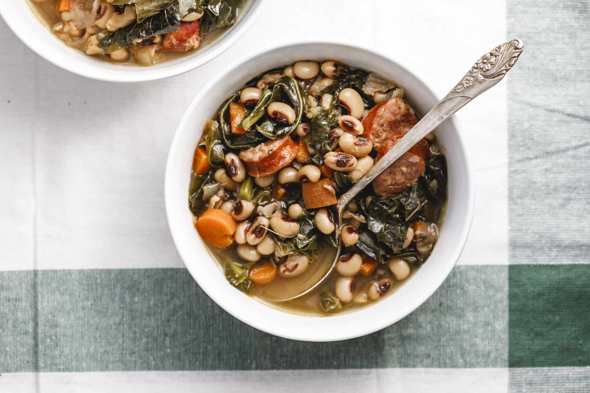 White Bowl of Instant Pot Black Eyed Pea Soup on a white and green napkin