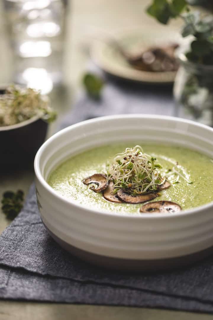 low carb broccoli cheddar soup in a white bowl with mushrooms