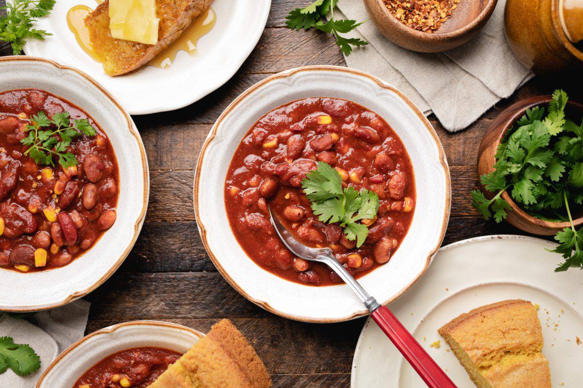 Vegan Chili in a white bowl with a spoon and cilantro