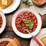 Vegan Chili in a white bowl with a spoon and cilantro