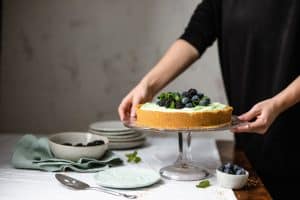 Placing a pistachio tart on a pie plate