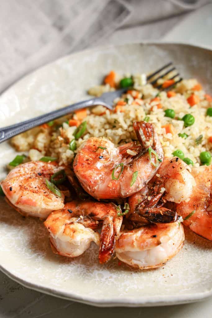 View of a plate of shrimp with fried rice and scallions