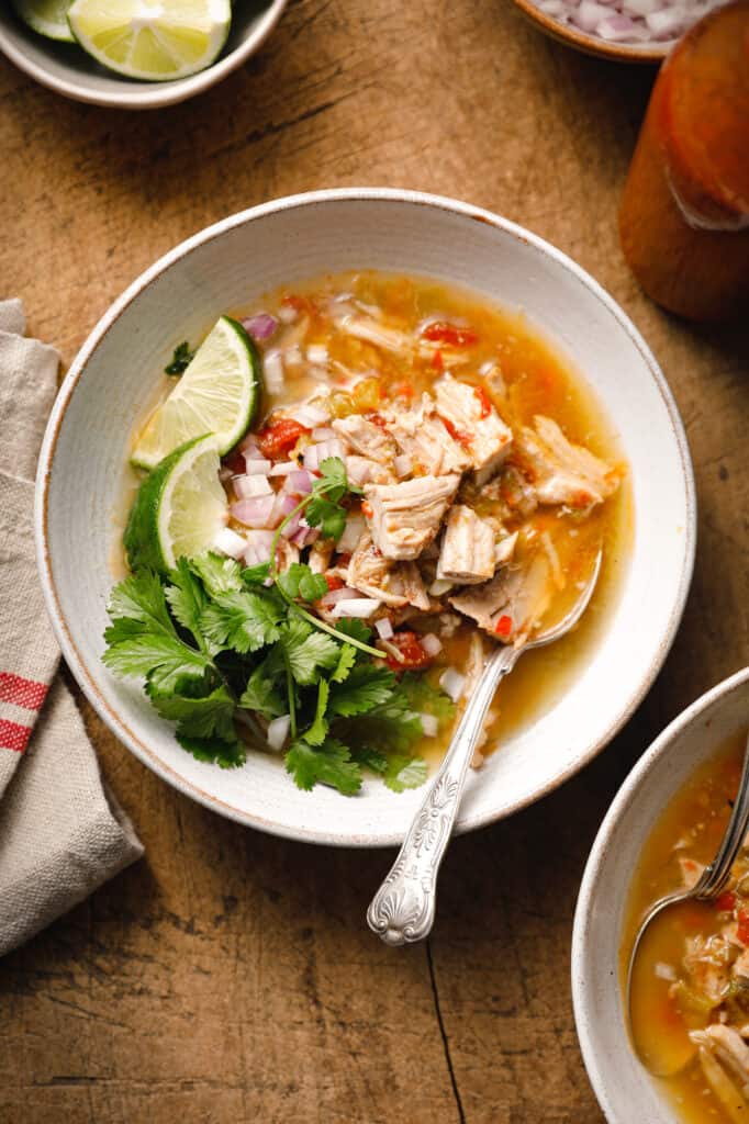 green chile pork stew in a bowl garnished with lime and cilantro