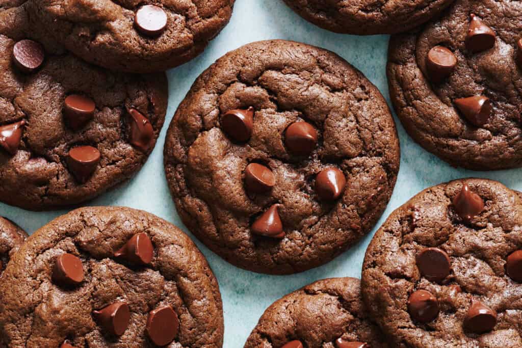 overhead view of double chocolate chip cookies on a blue background