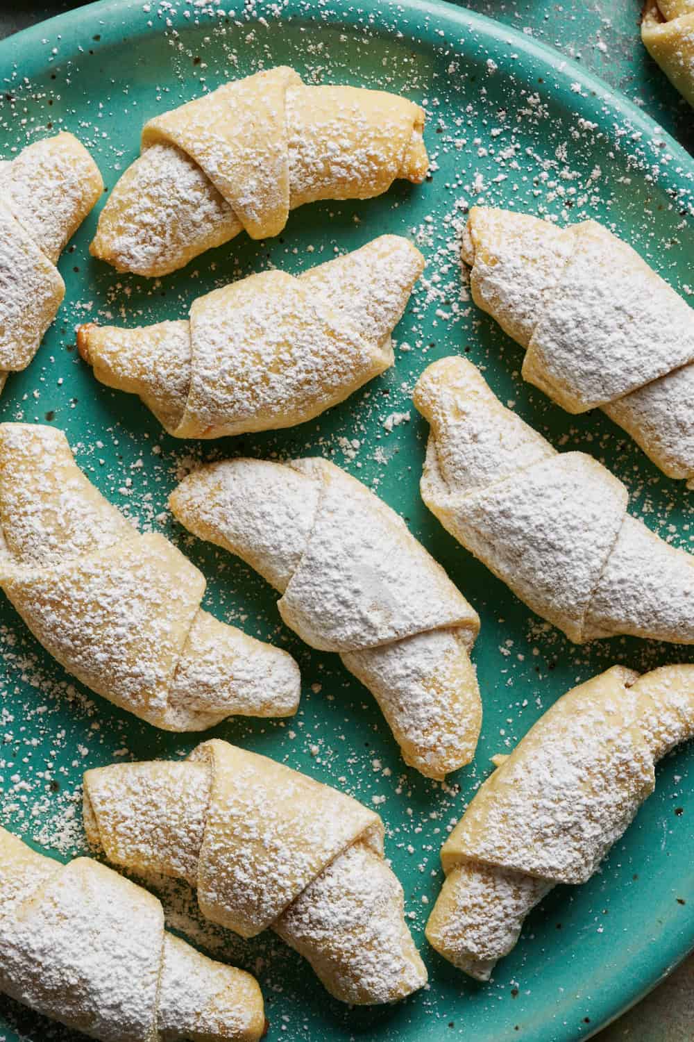 powdered sugar dusted kifle cookies on a plate