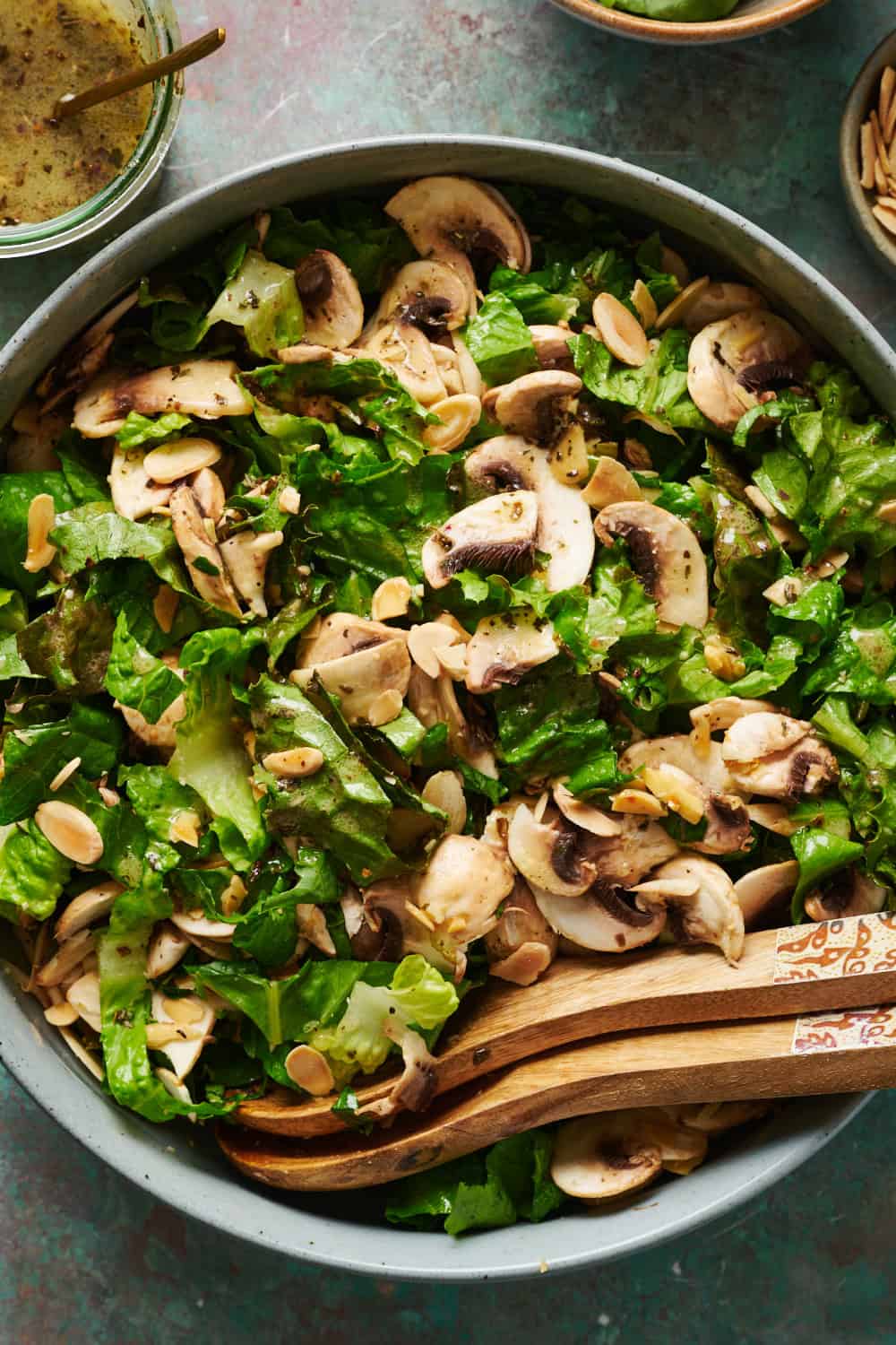 a green salad with fresh sliced mushrooms, almonds and a basil mustard dressing