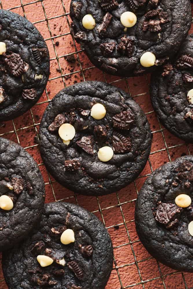 Chocolate Cookies and Cream Cookies on a cooling rack with crumbs sprinkled around.