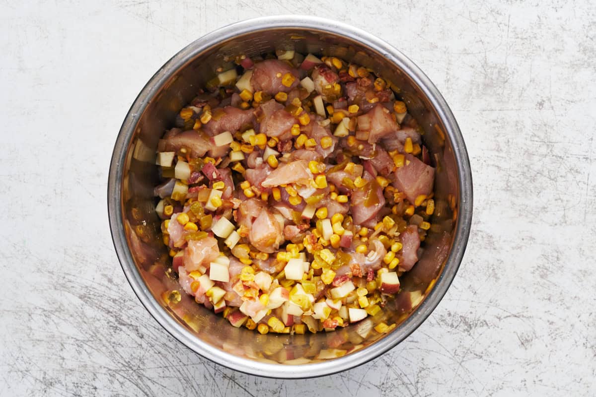 a bowl of chicken corn chowder with bacon bits on top