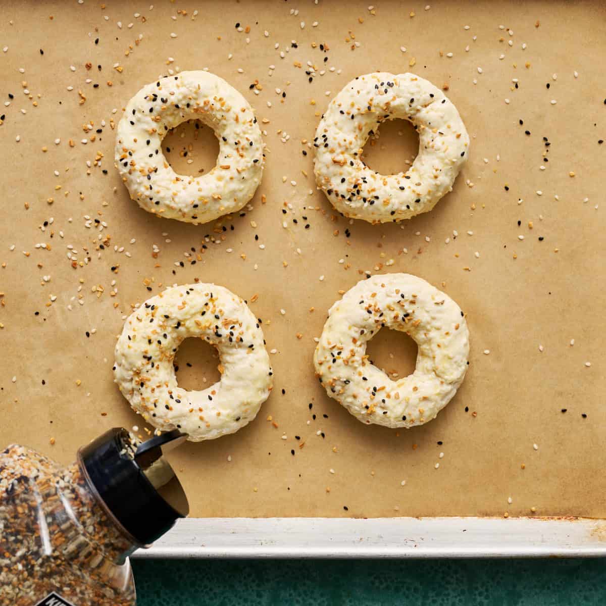 sprinkling seasoning on the bagels