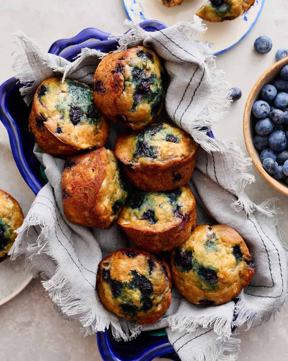 Cottage Cheese Blueberry Muffins stacked in a blue serving dish