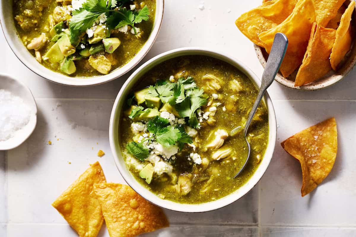 Bowl of chicken chili verde topped with cilantro served with chips