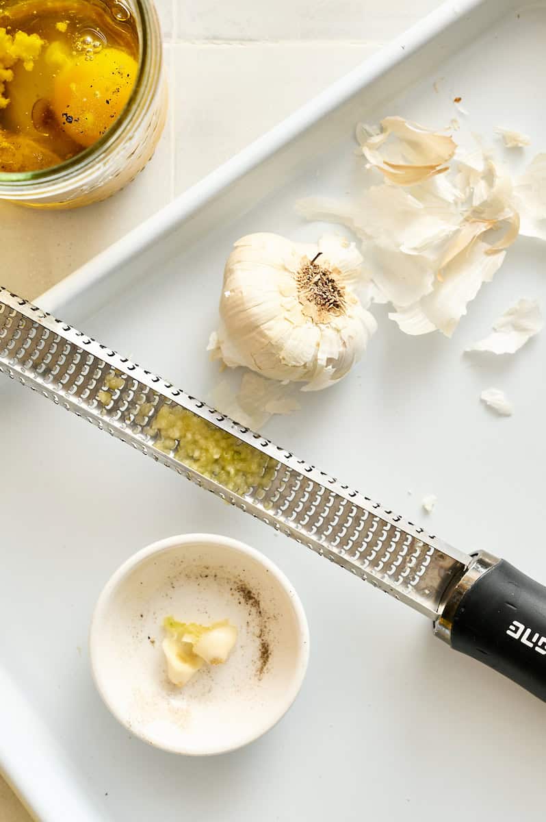 grating the cloves of garlic