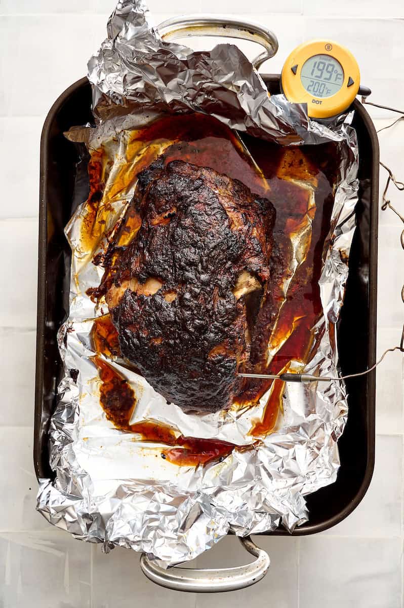 pork roast in the pan after cooking with the probe inserted and showing internal temp of 200F