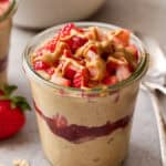 pb+j oats in a jar topped with berries and peanut butter drizzle