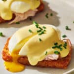 hash brown eggs benedict with a runny egg and topped with cottage cheese hollandaise and chives