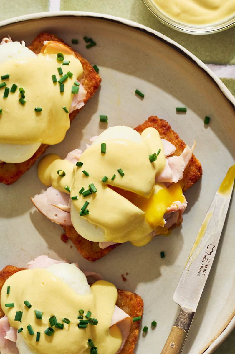 hash brown eggs benedict with a runny egg, shaved turkey, and topped with cottage cheese hollandaise and chives