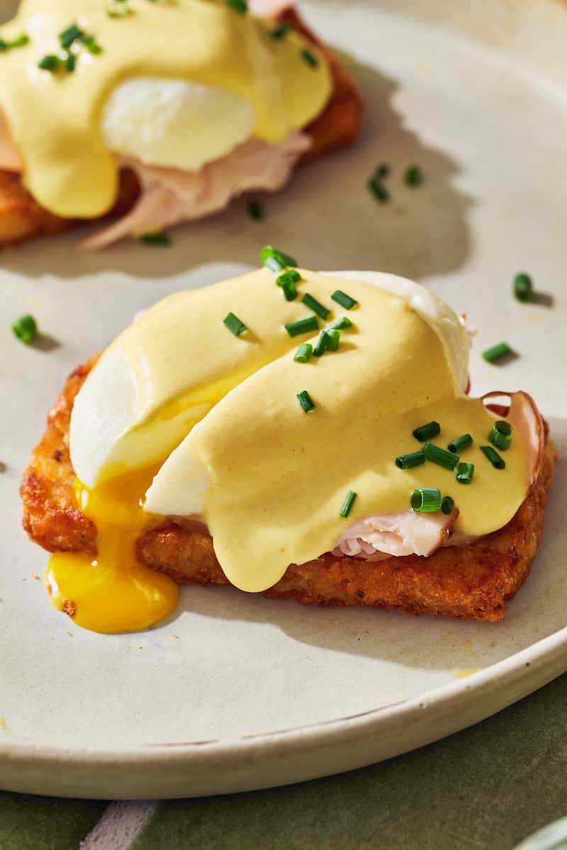 hash brown eggs benedict with a runny egg and topped with cottage cheese hollandaise and chives