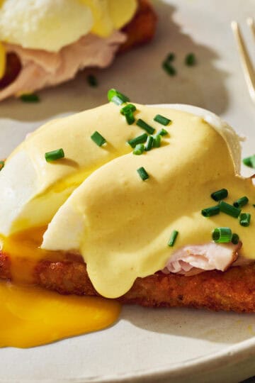 hash brown eggs benedict with a runny egg and topped with cottage cheese hollandaise and chives