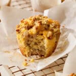 unwrapped muffin with a bite taken out on a cooling rack