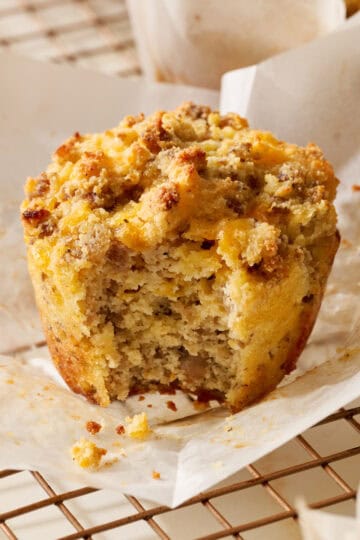 unwrapped muffin with a bite taken out on a cooling rack