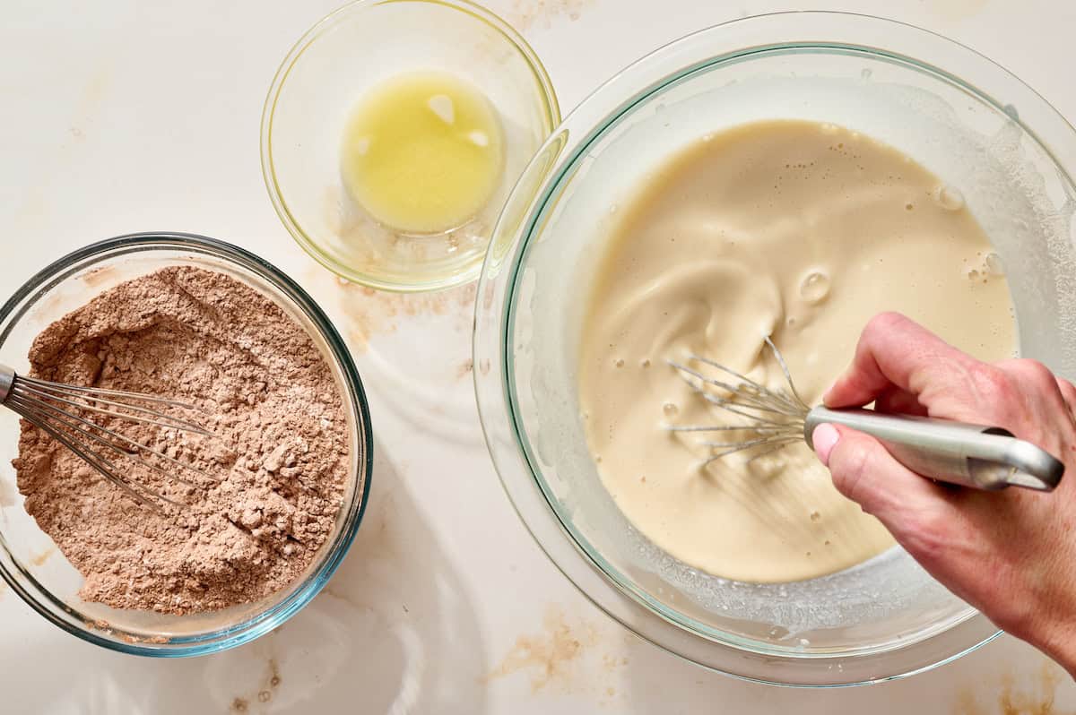 whisking the wet ingredients with the dry ingredients and butter ready to add