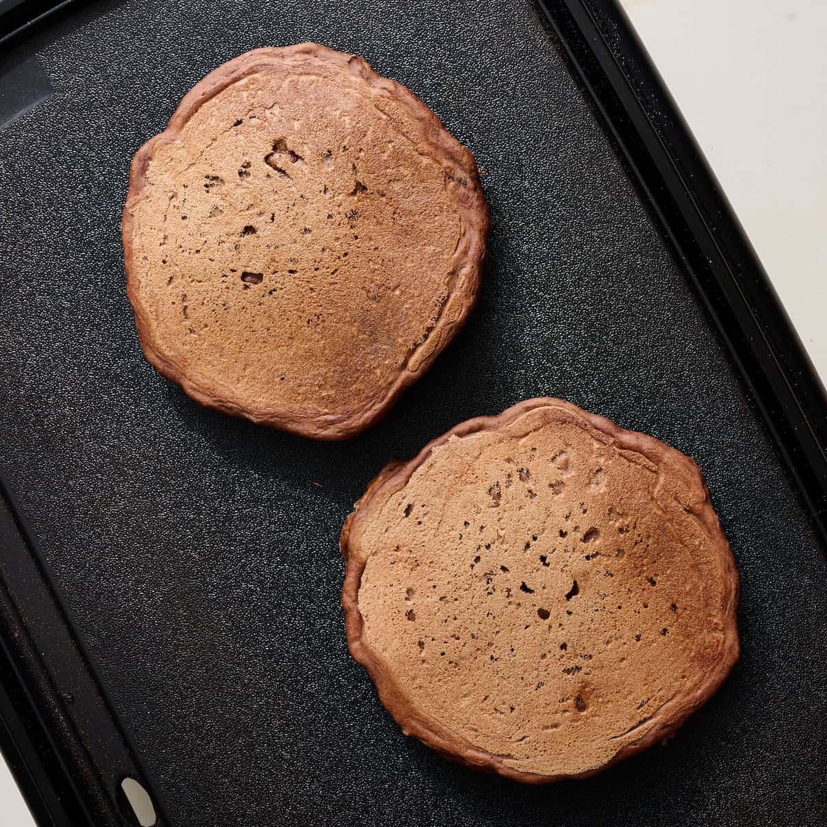 cooking chocolate pancakes on a griddle