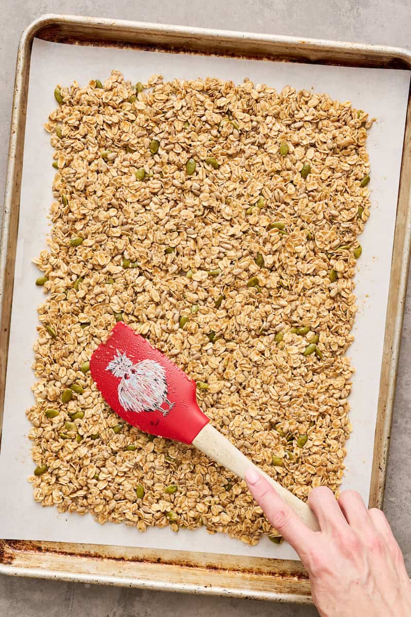 spreading granola mixture on a prepared baking sheet