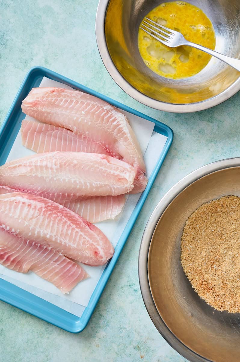 ingredients to make air fryer fish tacos including white fish, egg and the almond flour breading