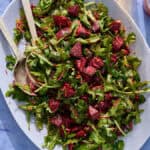 a bed of arugula topped with the beet mixture