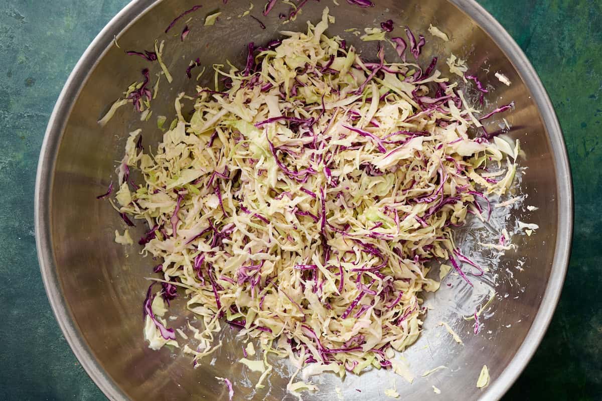 cabbage and dressing tossed in a large bowl