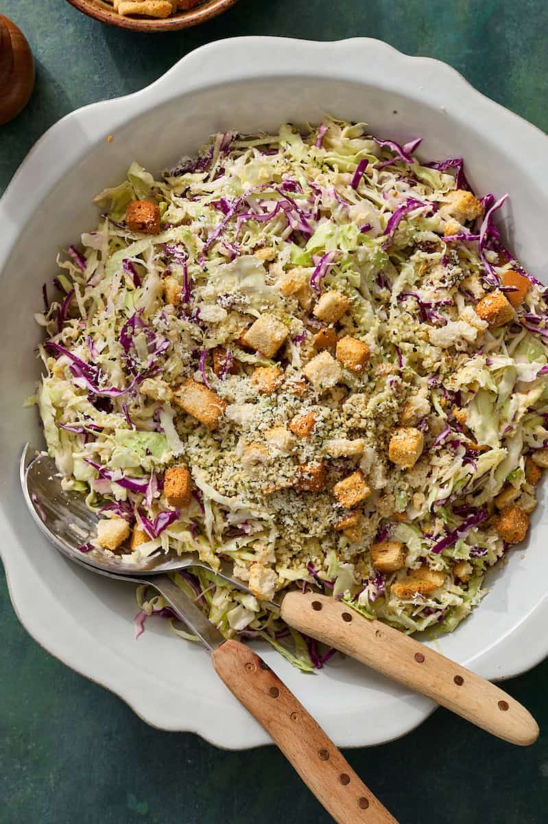 salad in a bowl with tongs topped with croutons ready to serve